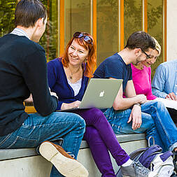 Studierende sitzen auf dem Campus der HTW Dresden